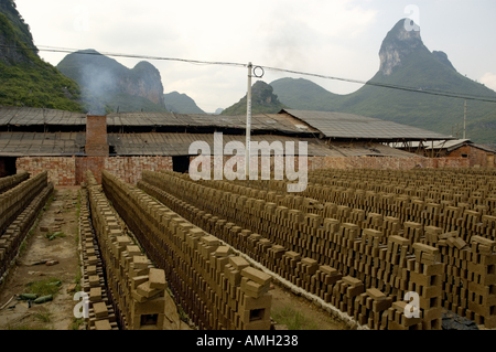 Cina guangxi vicino a yangshuo fabbrica in mattoni rossi tra i picchi di calcare e le risaie. Foto Stock