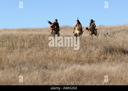 Tre Native American Indian uomini in esecuzione in discesa in morti di graminacee Foto Stock