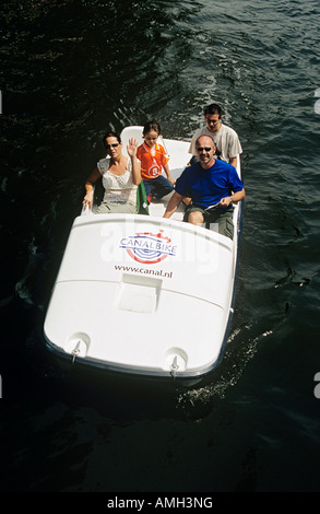 I turisti che viaggiano in un pedalò canalbike su un canale, Amsterdam, Olanda Foto Stock