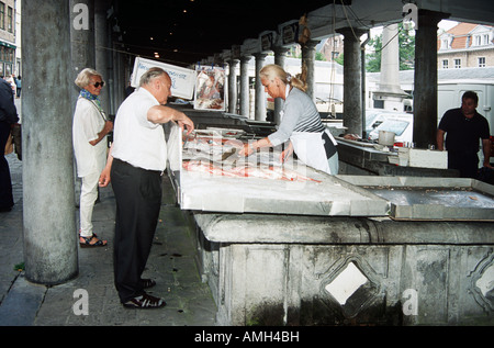 Persone che acquistano il pesce in un mercato di Bruges, Belgio Foto Stock