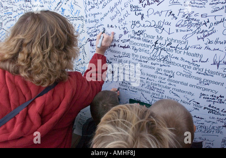 La firma di un biglietto di auguri di Natale di Alan Johnson, Segretario di Stato per la salute nel corso di una manifestazione contro il declassamento unità di maternità. Foto Stock