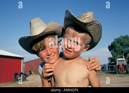 Due giovani ranch bambini con cappelli da cowboy e fratello e sorella sul loro papà s ranch vicino a amare New Mexico Foto Stock