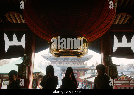 Tokyo Giappone pellegrini in preghiera presso il senso ji tempio Buddista complesso in Asakusa Foto Stock