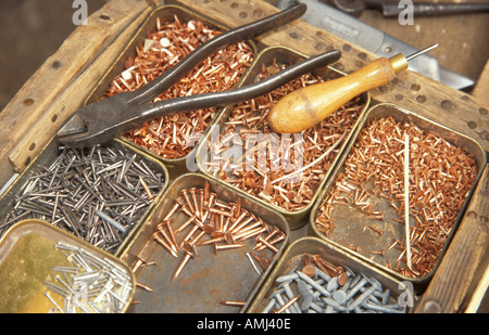 Vassoio di chiodi e chiodi con alcuni degli strumenti utilizzati da Tim Franks rendendo trugs giardino nel modo tradizionale a Herstmonceux. Foto Stock