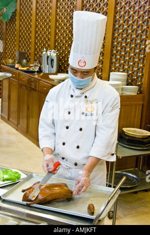 Lo Chef il taglio di Anatra alla Pechinese Da Dong Roast Duck Restaurant Pechino CINA Foto Stock