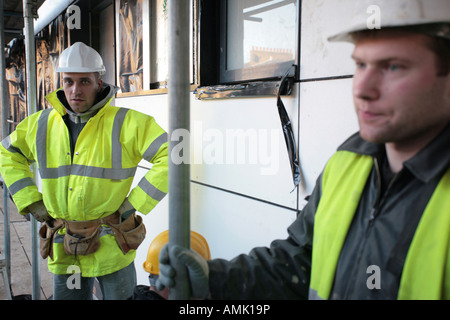 Il lituano lavoratori edili in piedi su un ponteggio in cantiere, Londra, Regno Unito. Foto Stock