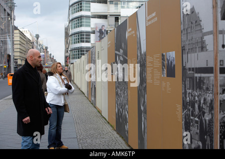 I turisti di leggere la storia del muro di Berlino al Checkpoint Charlie Berlino Germania Foto Stock