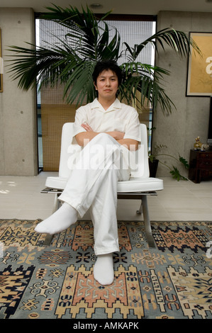Metà uomo adulto seduto su una sedia Foto Stock