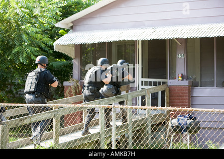 Funzionari di polizia da narcotici tattico di unità che effettua ad alto rischio di un mandato di perquisizione nel sospetto di casa di farmaco. Kansas City SWAT. Foto Stock