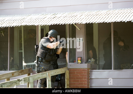 Funzionari di polizia da narcotici tattico di unità che effettua ad alto rischio di un mandato di perquisizione nel sospetto di casa di farmaco. Kansas City SWAT. Foto Stock