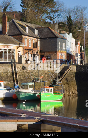 Barche da pesca legata a Padstow harbour parete, Cornwall. Pub, negozi, caffetterie e ristoranti. Garzetta uccello nell'acqua. Foto Stock