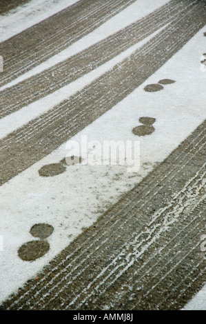 Stampe di avvio sulla strada innevata lungo il lato alcune tracce di pneumatici Foto Stock