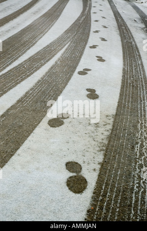 Stampe di avvio sulla strada innevata lungo il lato alcune tracce di pneumatici Foto Stock