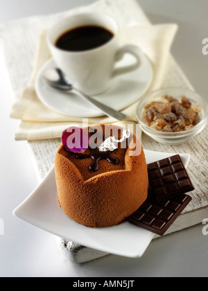 Una specialità di pasticceria fatta a mano ricca torta di cioccolato indulgente riempita con caffè in un ambiente di tavola bianco