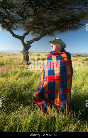 Peter Bender in Senior Elder robe di Masai in piedi nei pressi di Acacia nel Lewa Conservancy del Kenya Africa Foto Stock