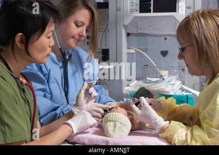 Gli infermieri la pratica sul manichino bambino Foto Stock