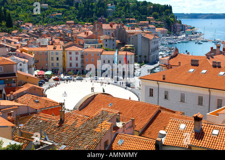 Vista di Tartini Square e il mare adriatico oltre la terra-cotta pan Mediterraneo piastrellato tetti di pirano, Balcans, Slovenia Foto Stock