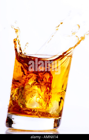 Il cubo di ghiaccio cadere nel bicchiere di Whiskey Foto Stock