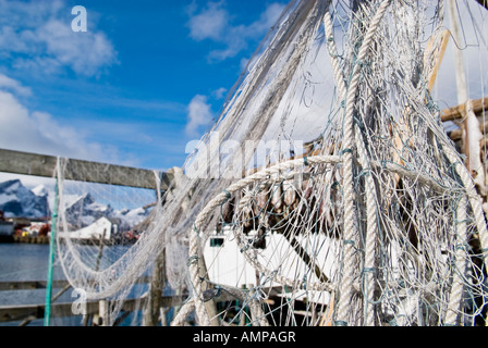 Aggrovigliato reti da pesca appesa su legno stoccafisso stendino, chiamato un fiocco, isole Lofoten in Norvegia Foto Stock