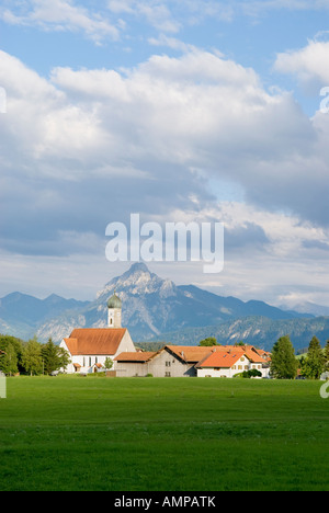 Vista sul campo di fattoria al piccolo villaggio bavarese di Speiden con la montagna Saeuling nella distanza, Allgaeu, Germania Foto Stock
