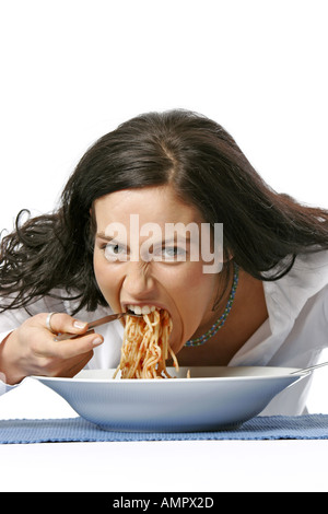 Giovane donna mangiare spaghetti Foto Stock