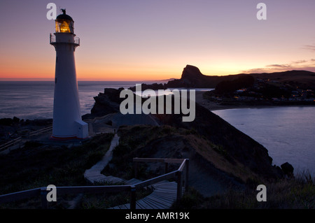 Tramonto a Castlepoint faro che si affaccia sulla laguna e bay, Castlepoint, Wairarapa, Isola del nord, Nuova Zelanda. Foto Stock