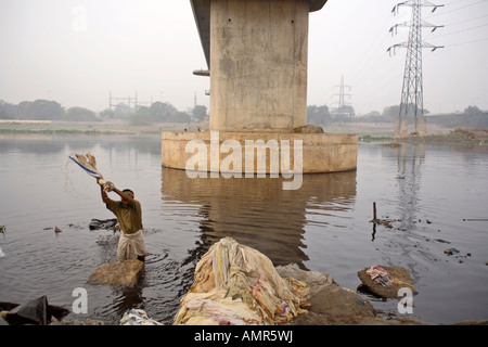 Un Dhobi Wallah lava vestiti nella Yamuna dal Kudsia Ghat a Delhi Foto Stock