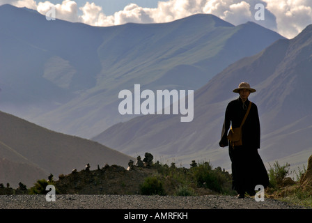 Pellegrino buddista a piedi la strada per un passo di montagna del Tibet Foto Stock
