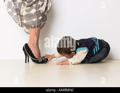 Baby Boy affascinato dalla Madre di scarpe Foto Stock