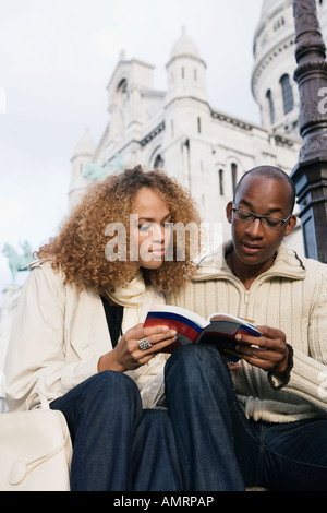 African giovane guardando il libro guida Foto Stock
