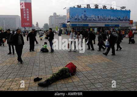 Senzatetto uomo giace a terra nel centro di Wuhan, provincia di Hubei in Cina. 20 Ott 2007 Foto Stock