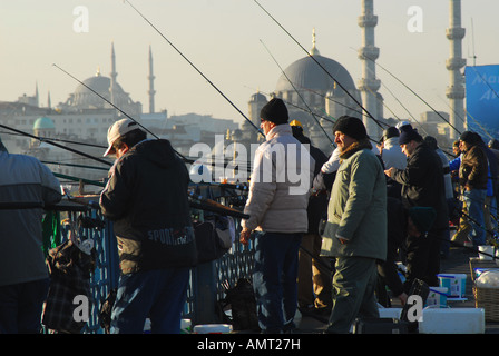 ISTANBUL. La pesca di linea dal Ponte Galata sul Golden Horn, con la Yeni e Nuruosmaniye moschee dietro. 2007. Foto Stock