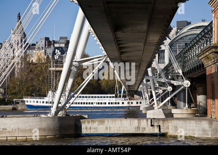 Hungerford bridge con la stazione di Charing Cross in background come visto dalla riva sud del fiume Tamigi, London Inghilterra England Foto Stock