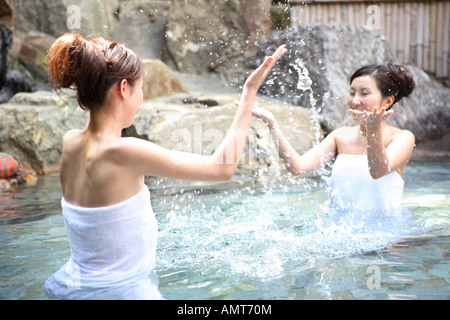 Le donne giapponesi di bere bene in un open-air bath Foto Stock