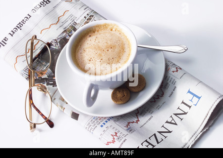 Tazza di caffè e i bicchieri sul giornale Foto Stock