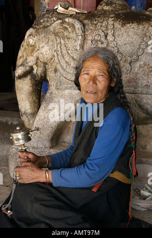 Ritratto di un anziano tibetano donna la filatura di una ruota di preghiera Monastero di Samye Tibet Foto Stock