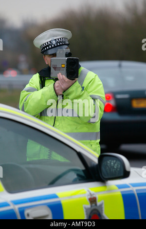 Il traffico britannico funzionario di polizia controlla la velocità del traffico su strada utilizzando una pistola radar Foto Stock