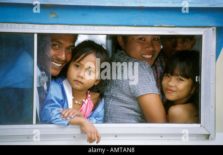 Filippine famiglia guardando fuori della finestra del bus Foto Stock