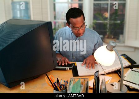Un uomo nero che lavora in un ufficio a casa Foto Stock