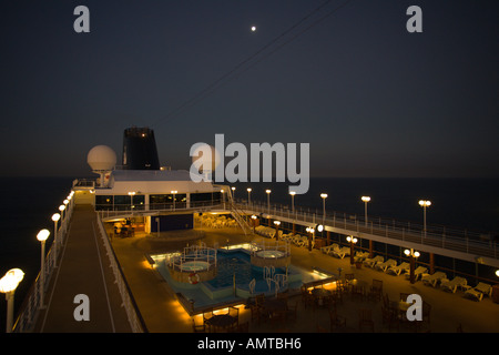 Guardando verso poppa sul ponte superiore della crociera nave passeggeri con la luna piena su nave mentre in mare di notte in Oceano Pacifico Foto Stock