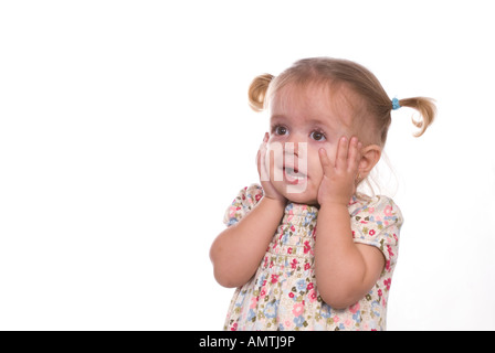 Scioccato bionda bambina con le mani sul viso Foto Stock