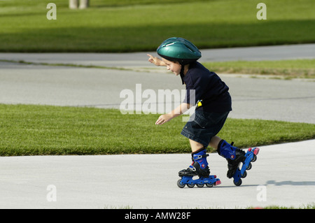 6 anno vecchio ragazzo roller blade mentre indossa il casco di protezione Foto Stock