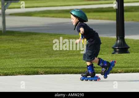 6 anno vecchio ragazzo roller blade mentre indossa il casco di protezione Foto Stock