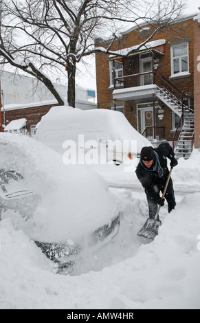 L'uomo scavo auto dopo una grande tempesta di neve in Quebec Montreal Canada Foto Stock