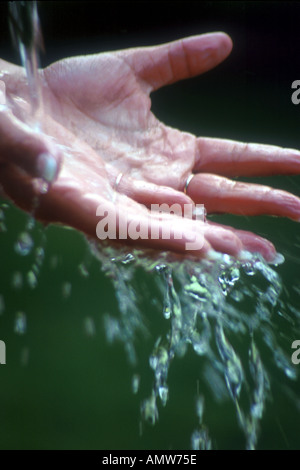 Acqua di versarla sulla mano Foto Stock