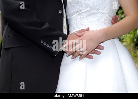 Sposa e lo sposo tenendo le mani ad un matrimonio che mostra anelli Foto Stock