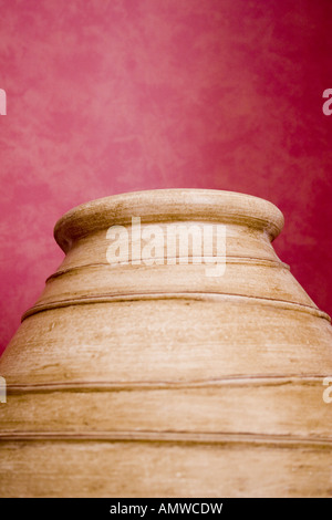 Pentola di coccio contro lo sfondo rosso Foto Stock