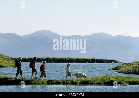 Famiglia vagare nei pressi di un lago di montagna, Francia, Alpi Foto Stock