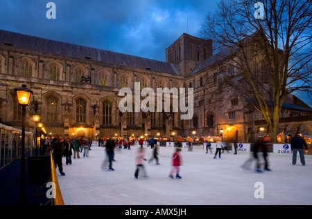 La Cattedrale di Winchester a Natale con la pista di pattinaggio su ghiaccio e mercato di notte,Winchester,Hampshire, Inghilterra. Foto Stock