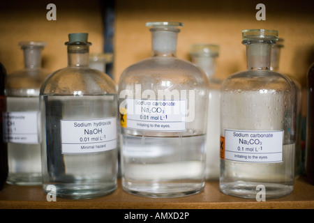 Memorizzazione vetro vasi contenenti le sostanze chimiche in un laboratorio scolastico Foto Stock